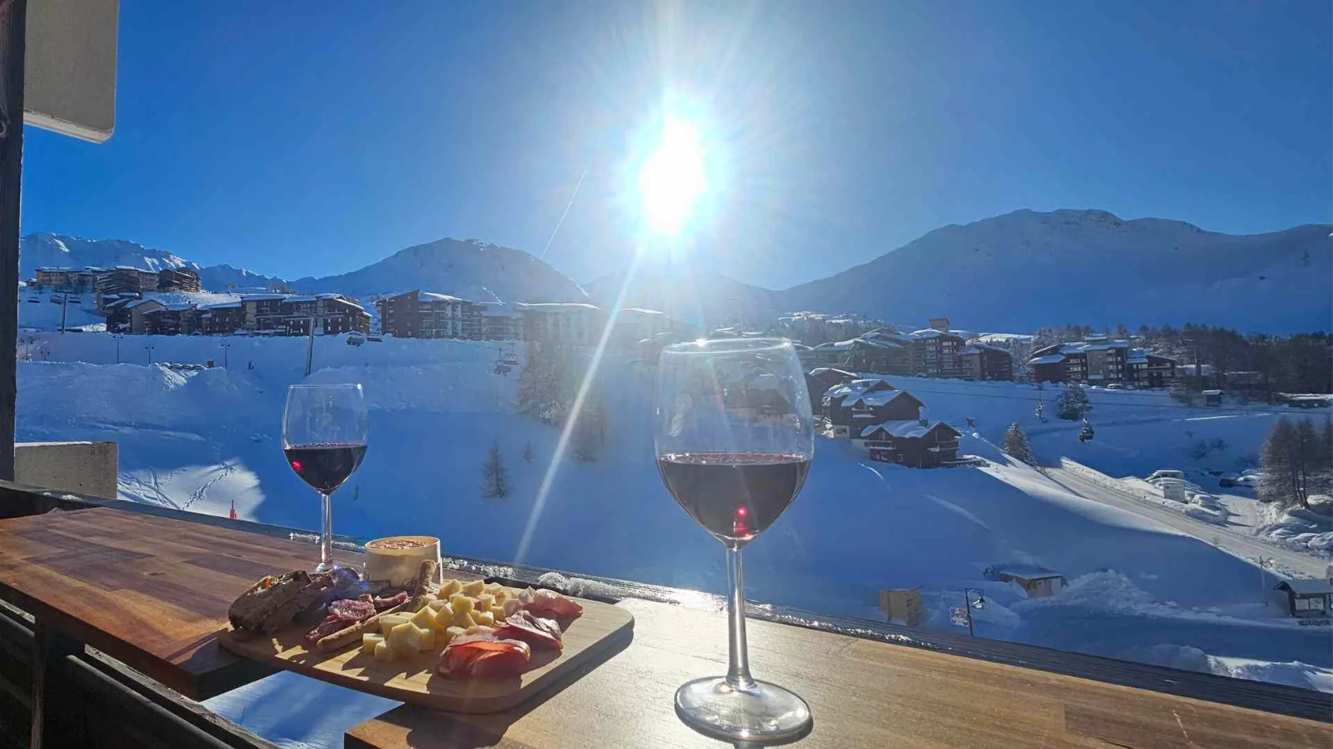Apéro hiver sur le balcon, plateau charcuterie-fromage et vue panoramique sur La Plagne Soleil